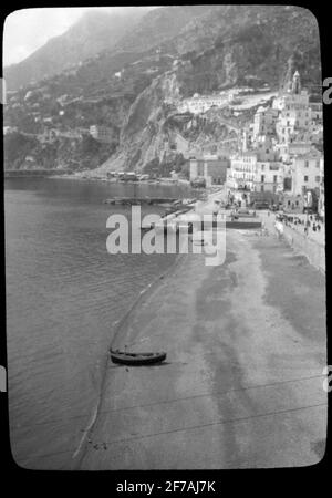 Skiopticon image from the Department of Photography at the Royal Institute of Technology. Motive depicting urban buildings at hillside near beach, probably in southern Italy. The picture is probably taken by John Hertzberg during a trip in Europe ..