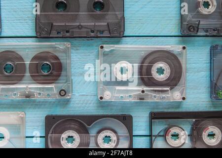 Several old audio cassettes are staggered against a blue wooden background. Close-up. Top view Stock Photo