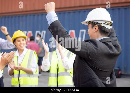 Unity and success concept.Bottom view of Engineer team people standing hands holding together at the container yard. Stock Photo