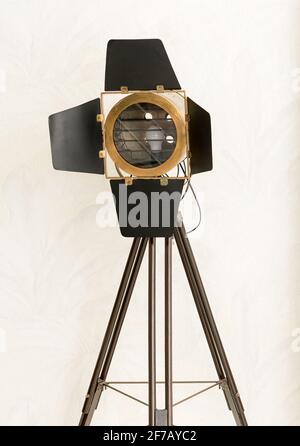 Vintage SLM studio light or lamp on a tripod stand with electric bulb behind the glass and folding flaps to direct the beam isolated on white Stock Photo