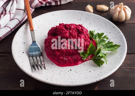 Salad of grated beetroot pine nuts and parsley with cream sauce on a plate Stock Photo