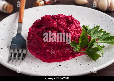 Salad of grated beetroot pine nuts and parsley with cream sauce on a plate Stock Photo