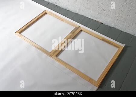 A female artist cutting canvas to prepare her own picture supports. Stock Photo