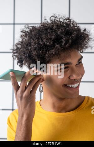 African american young guy with a smartphone listening to a voice message Stock Photo