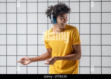 African american young guy in earphones listening to music and dancing Stock Photo