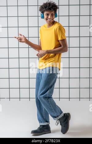African american young guy in earphones listening to music and dancing Stock Photo