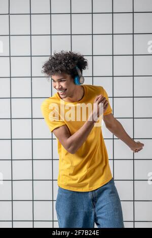 African american young guy in earphones listening to music and dancing Stock Photo