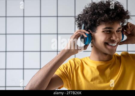 African american young guy in earphones smiling and looking happy Stock Photo