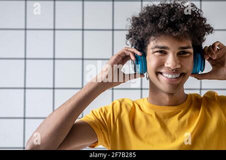 African american young guy in earphones smiling and looking happy Stock Photo