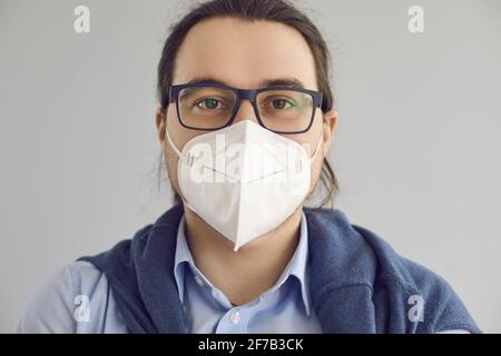 Headshot of man wearing KN95 face mask to protect himself from Covid 19 infection Stock Photo
