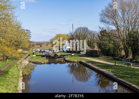 A pretty white cottage next to a quiet lock on the Rufford branch the Leeds Liverpool Canal near Burscough, Lancashire in April 2021. Stock Photo