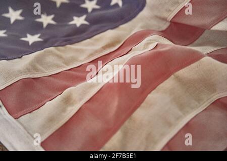 Worn United States Flag laying on table faded and old Stock Photo