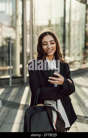 Smiling businesswoman checking cell phone Stock Photo