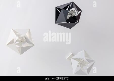 Modern pendant light hexagonal shape hanging from white ceiling. Stock Photo