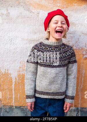 Girl in red beret and sweater, gazing pensively with hand to face by ...