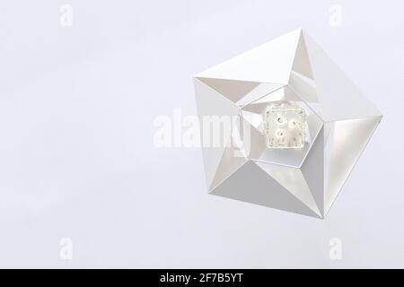 Geometric white modern metal chandelier hanging from the white ceiling, bottom view. Stock Photo