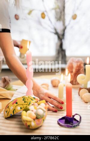 Woman putting candles on Easter table Stock Photo
