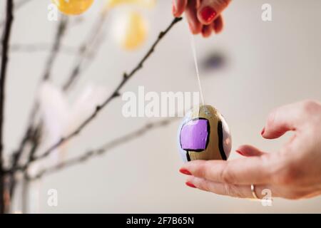 Woman's hands hanging Easter decoration Stock Photo