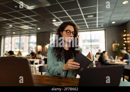 Businesswoman checking diary in cafe Stock Photo