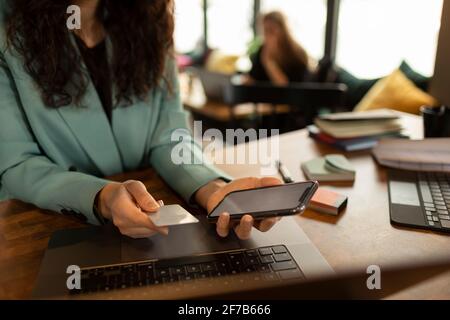 Woman's hands holding cell phone and credit card Stock Photo