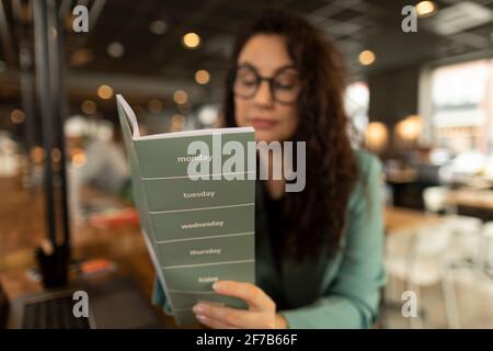 Businesswoman checking diary in cafe Stock Photo