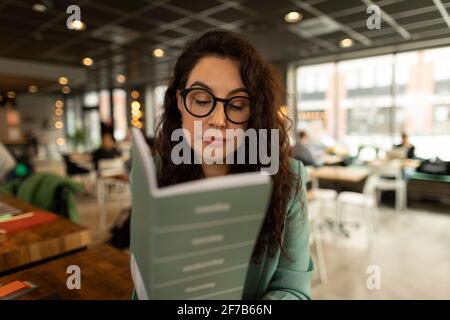 Businesswoman checking diary in cafe Stock Photo