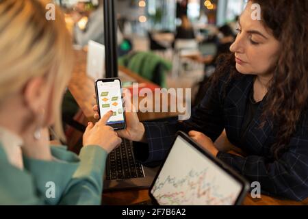 Woman  holding cell phone with business presentation Stock Photo