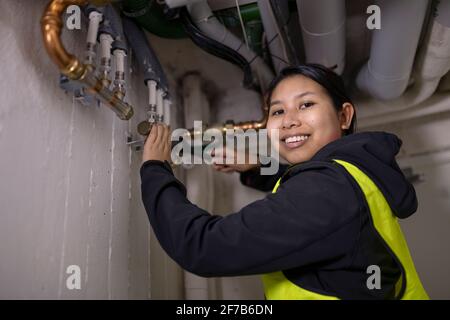 Female plumber fixing pipes Stock Photo