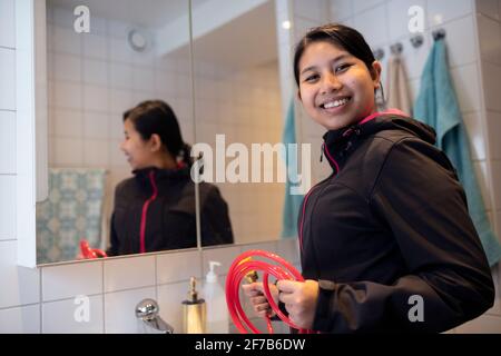 Smiling woman fixing bathroom sink Stock Photo