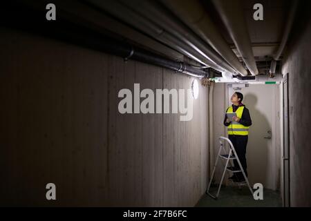 Female plumber checking pipes Stock Photo
