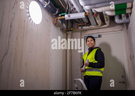 Female plumber checking pipes Stock Photo