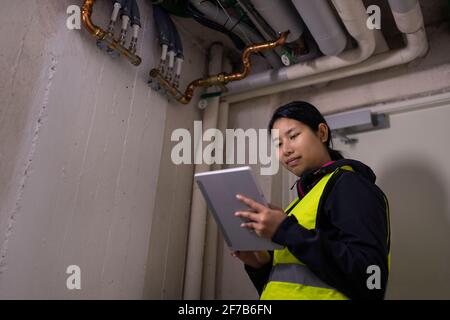 Female plumber checking pipes Stock Photo