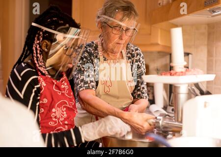 Women preparing sausages in kitchen Stock Photo