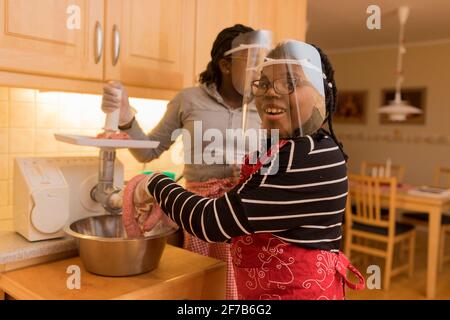 Women preparing sausages in kitchen Stock Photo
