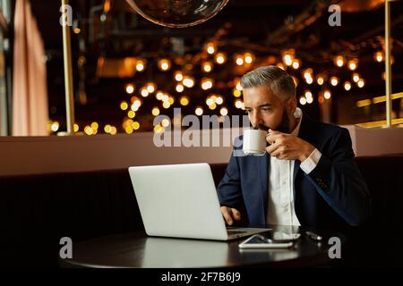Businessman using laptop in cafe Stock Photo