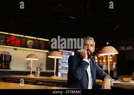 Businessman talking via cell phone in cafe Stock Photo