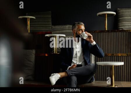 Businessman drinking coffee in cafe Stock Photo