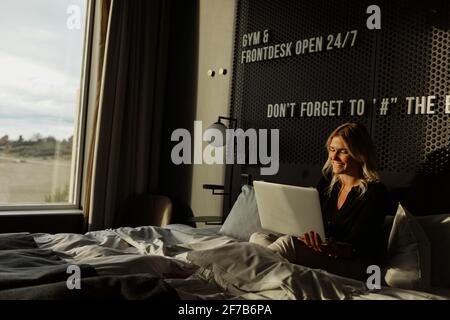 Woman in hotel room using laptop Stock Photo