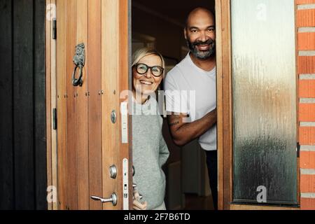Smiling mature couple at front door Stock Photo