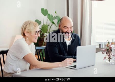 Couple using laptop at home Stock Photo