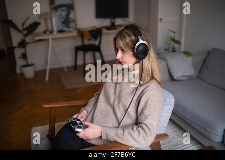 Young woman with headset playing video game Stock Photo