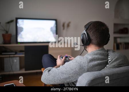 Man with headset playing video game Stock Photo