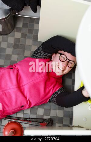 Female plumber repairing bathroom sink Stock Photo