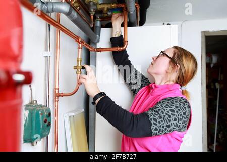 Female plumber checking pipes Stock Photo
