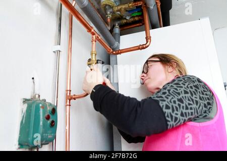 Female plumber checking pipes Stock Photo