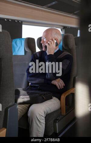Senior man traveling by train Stock Photo