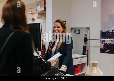 Smiling shop assistant walking to client Stock Photo