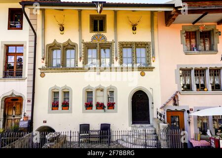 Old house by market square in Gruyères town. Gruerius, the of Gruyères, captured a crane and chose it as his heraldic animal. The city's coat of arms Stock Photo