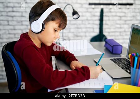 Side view of schoolboy doing homework with math Stock Photo