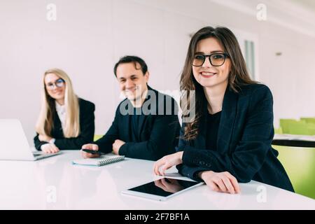 Shot of startup business team brainstorming and working on laptop and computer. Three people working together in office over new business project. Stock Photo